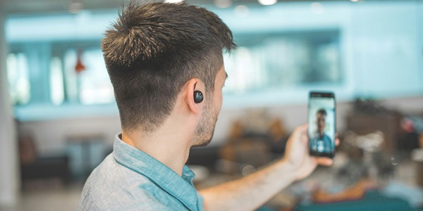A man in a modern office having a video call on a mobile phone over a WiFi network