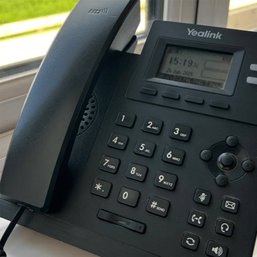 A Yealink VoIP phone on an office desk